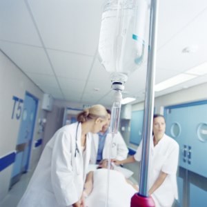 Image of a man on a gurney being wheeled down a hallway at a hospital